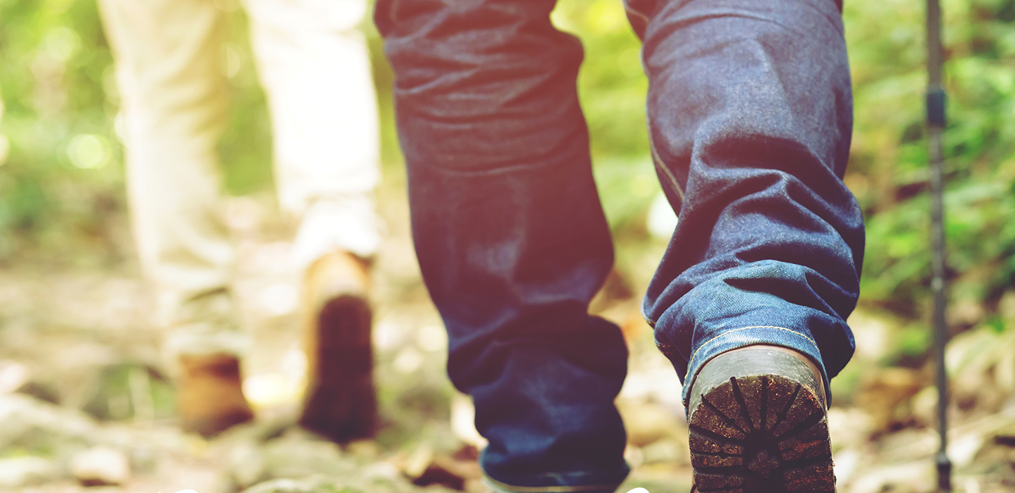 Twee mensen wandelen samen door een herfstig bos